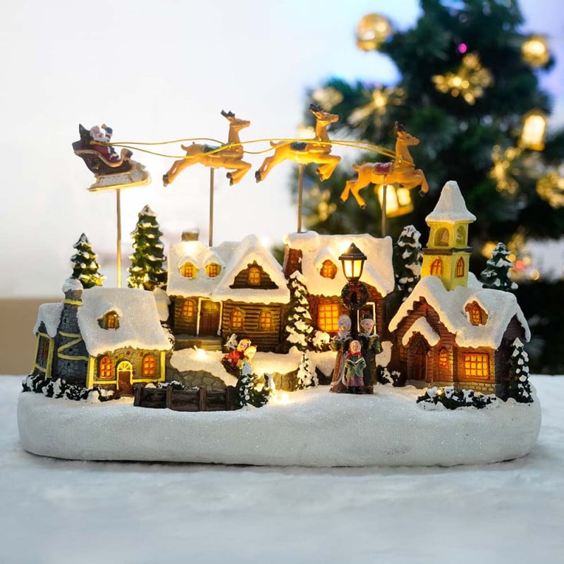 Village de Noël avec traîneau volant - animé à piles et lumineux Village de Noël avec traîneau volant - animé à piles et lumineux
